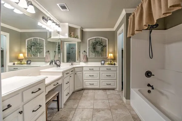 a spacious bathroom with a granite countertop sink a mirror a bathtub and shower