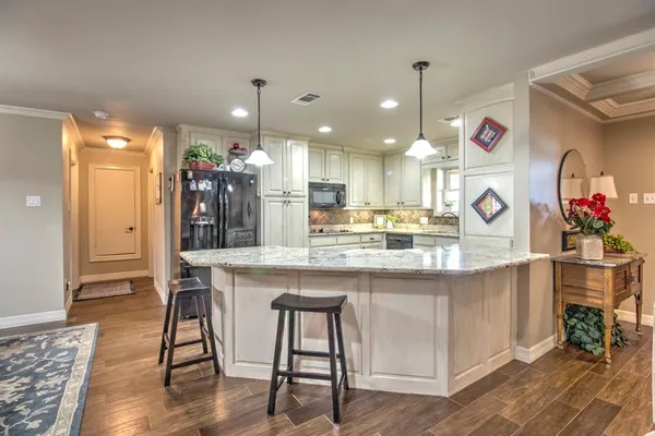 a kitchen with stainless steel appliances kitchen island granite countertop a table and chairs in it