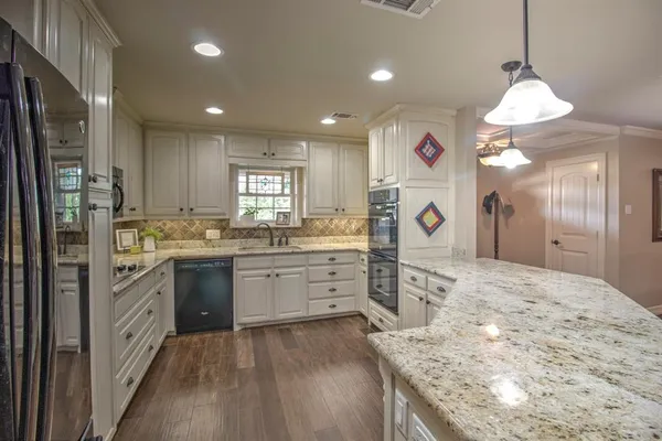 a kitchen with a refrigerator sink and cabinets