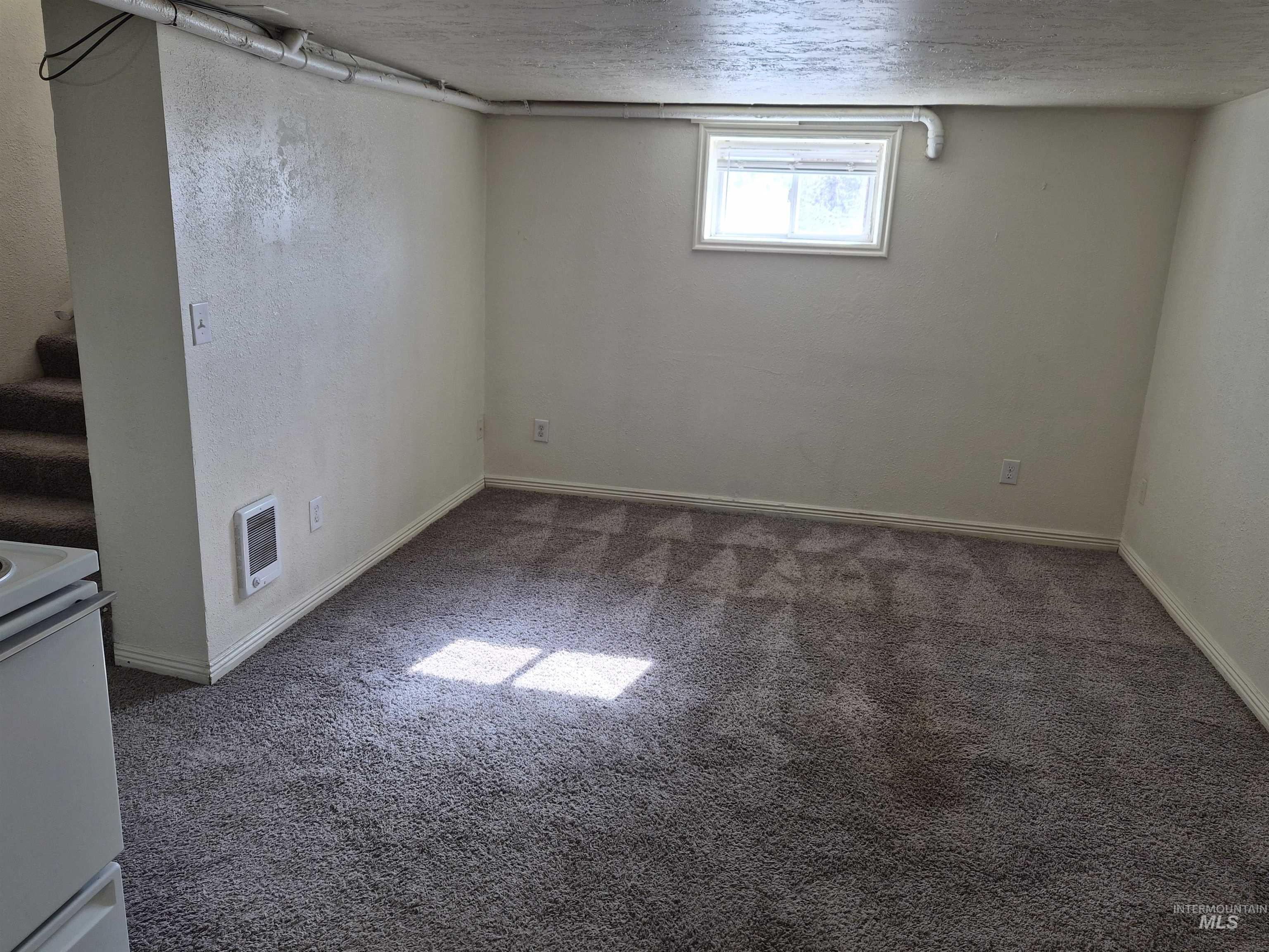 682 Randolph Avenue Pocatello, ID 83201 - Photo 13 of 29 Basement with a textured ceiling, carpet flooring, heating unit, and a textured wall