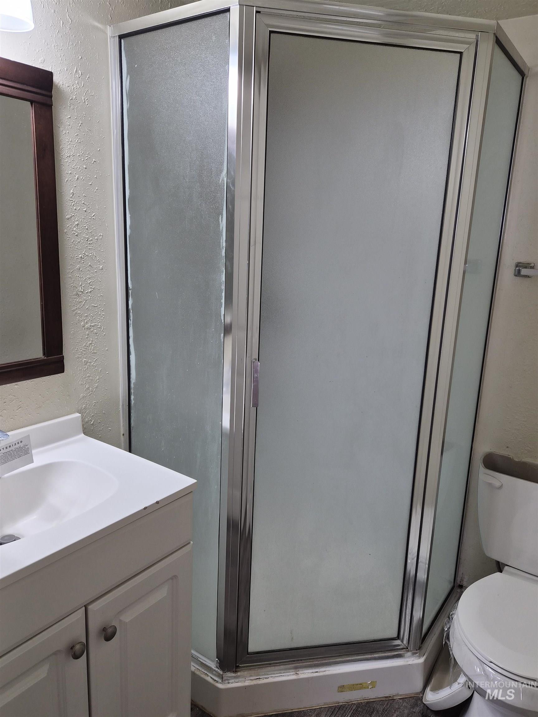 682 Randolph Avenue Pocatello, ID 83201 - Photo 16 of 29 Full bathroom featuring a textured wall, vanity, and a shower stall