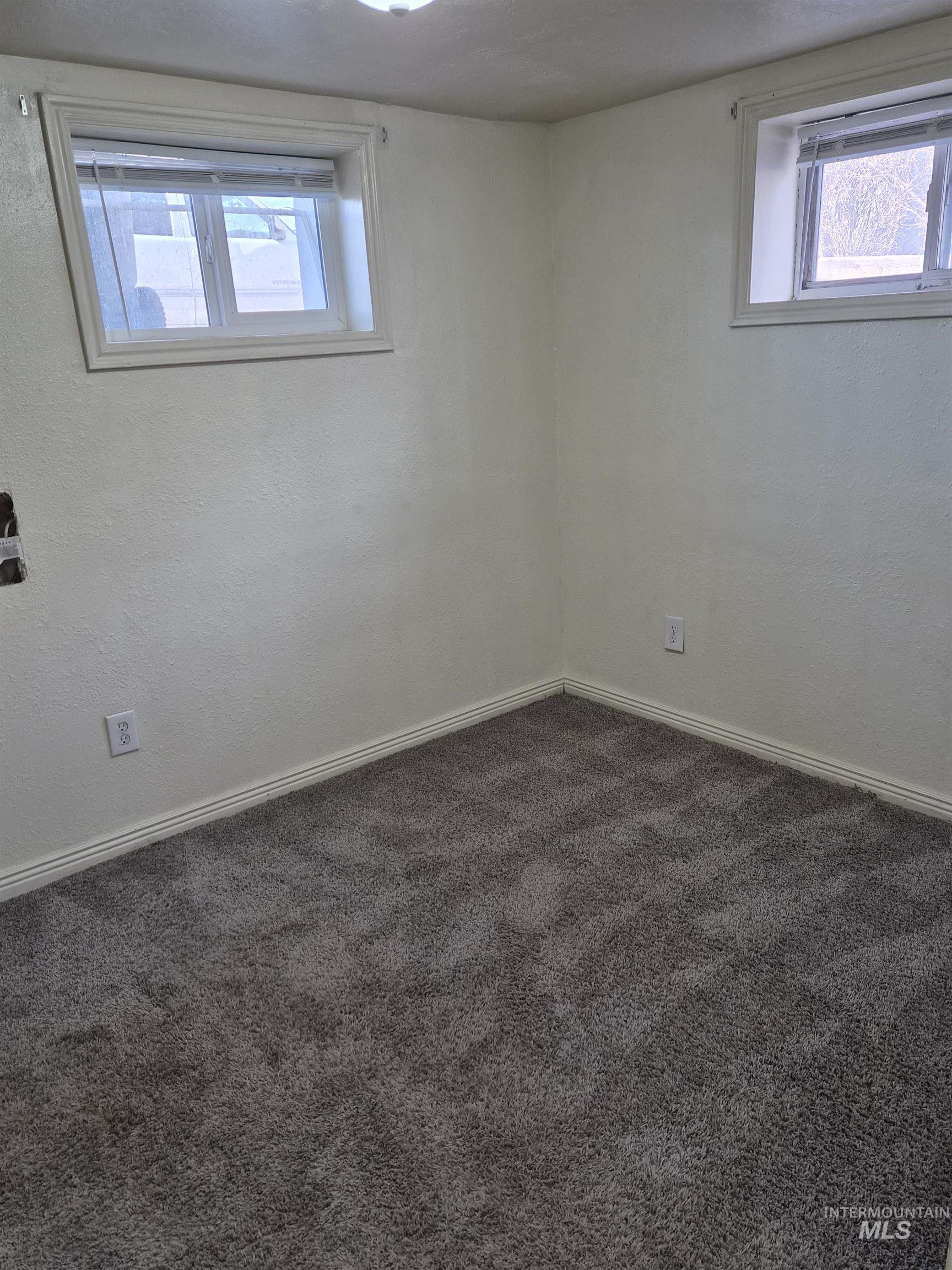 682 Randolph Avenue Pocatello, ID 83201 - Photo 17 of 29 Spare room featuring dark colored carpet and a textured wall