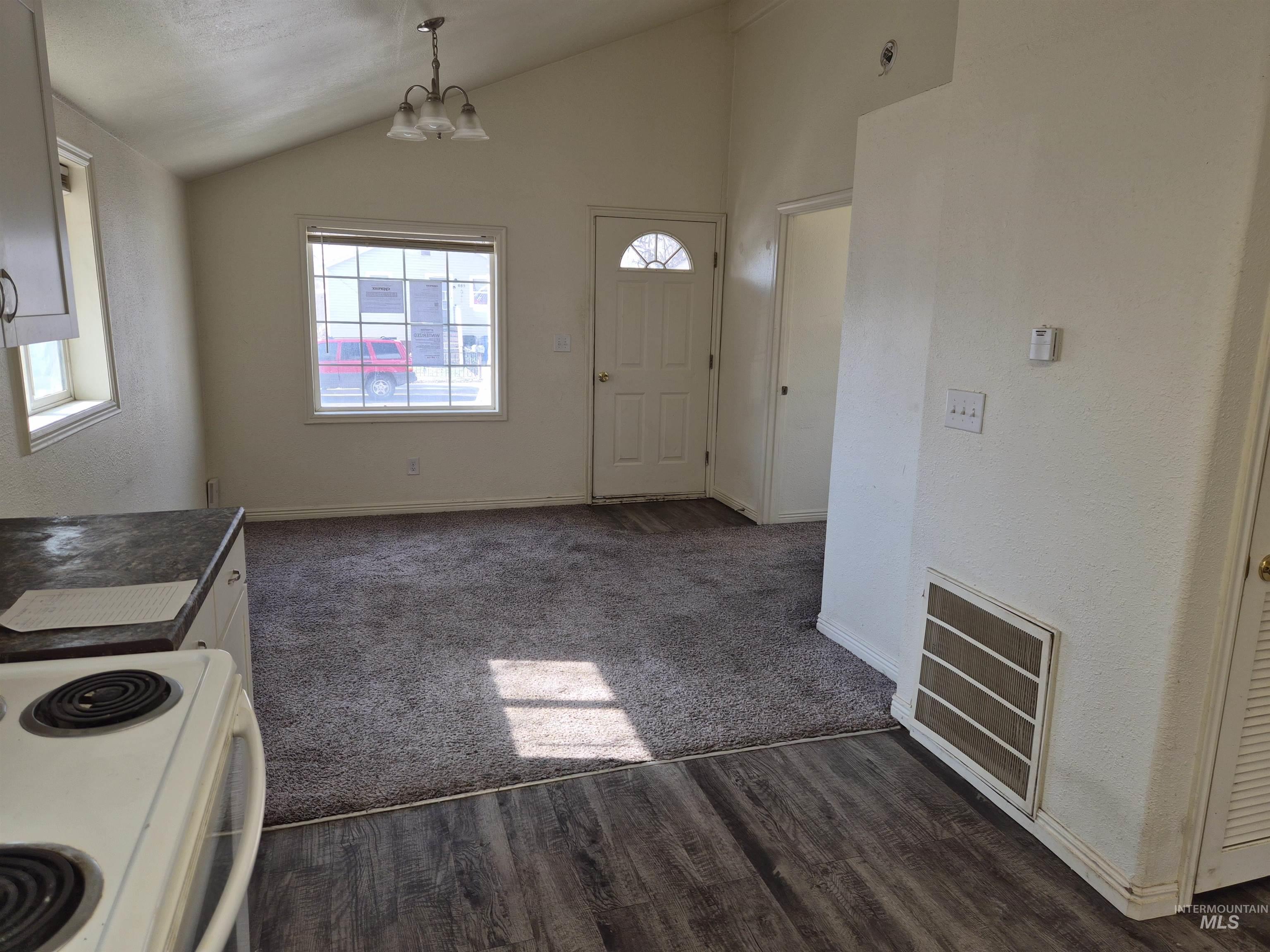 682 Randolph Avenue Pocatello, ID 83201 - Photo 4 of 29 Kitchen with vaulted ceiling, suspended lighting, white electric stove, dark wood-style floors, and dark countertops