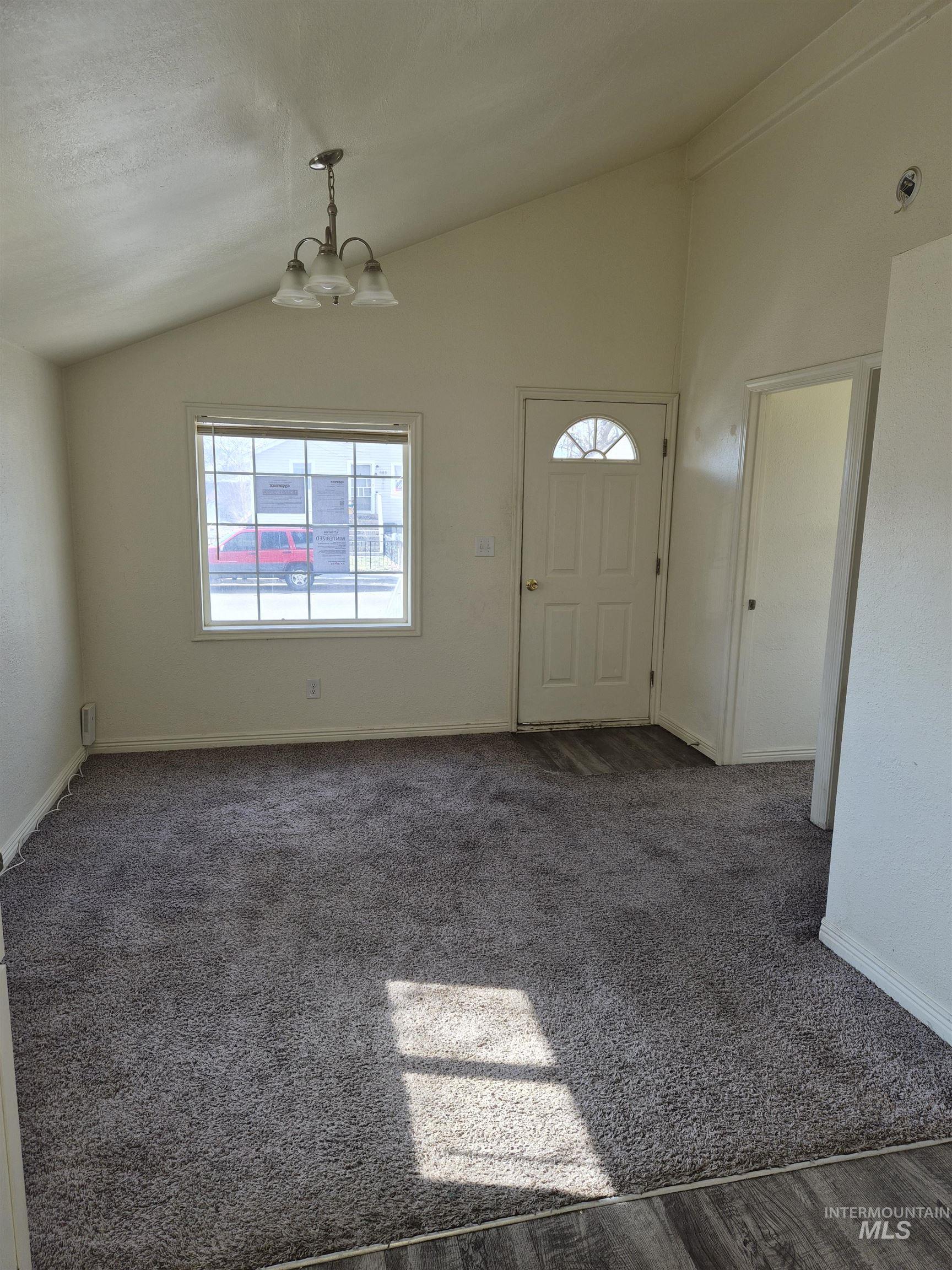 682 Randolph Avenue Pocatello, ID 83201 - Photo 5 of 29 Entryway with vaulted ceiling, hanging lights, and dark carpet