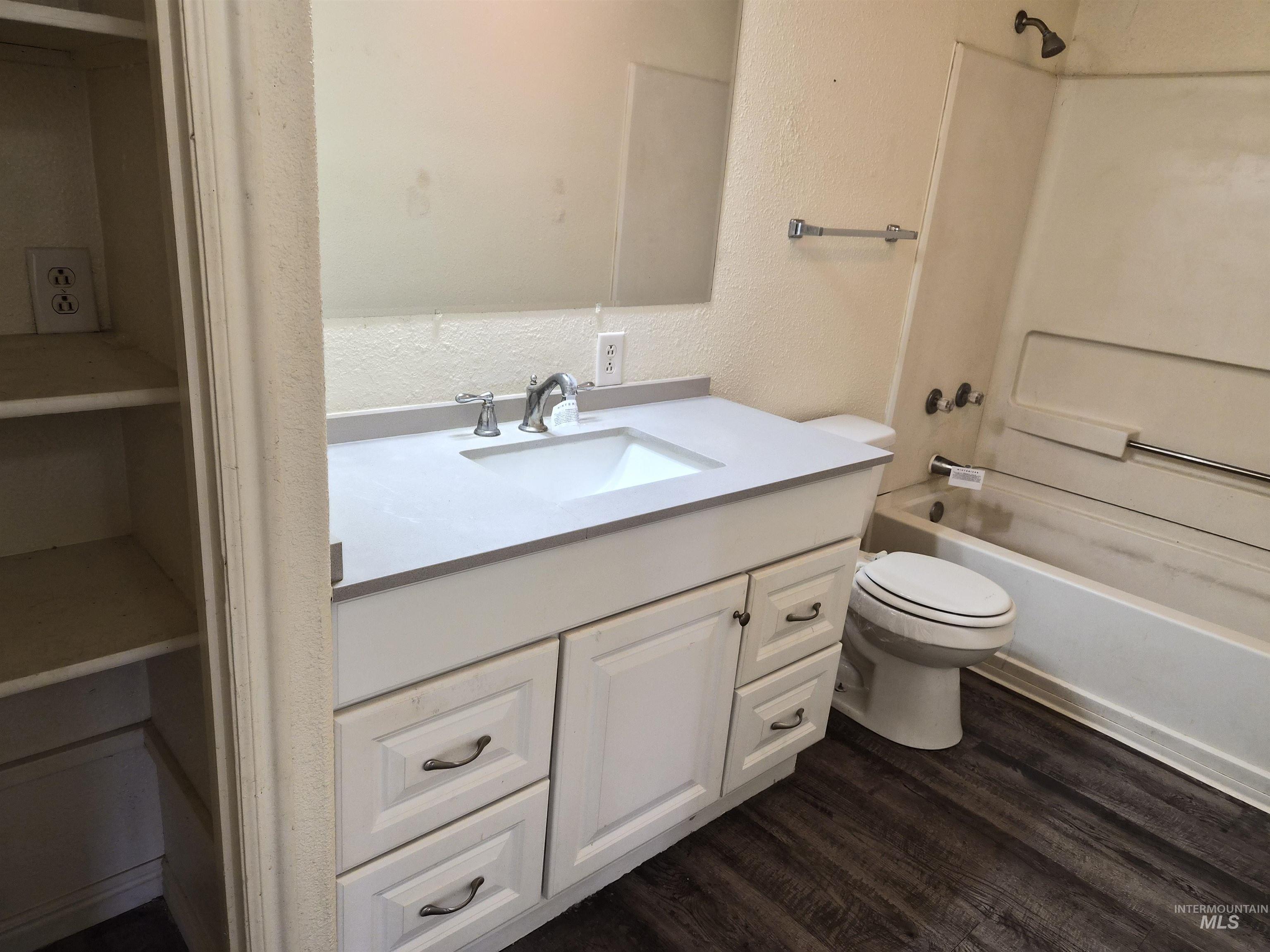 682 Randolph Avenue Pocatello, ID 83201 - Photo 6 of 29 Full bath with a textured wall, vanity, shower / bath combination, and dark wood-style floors