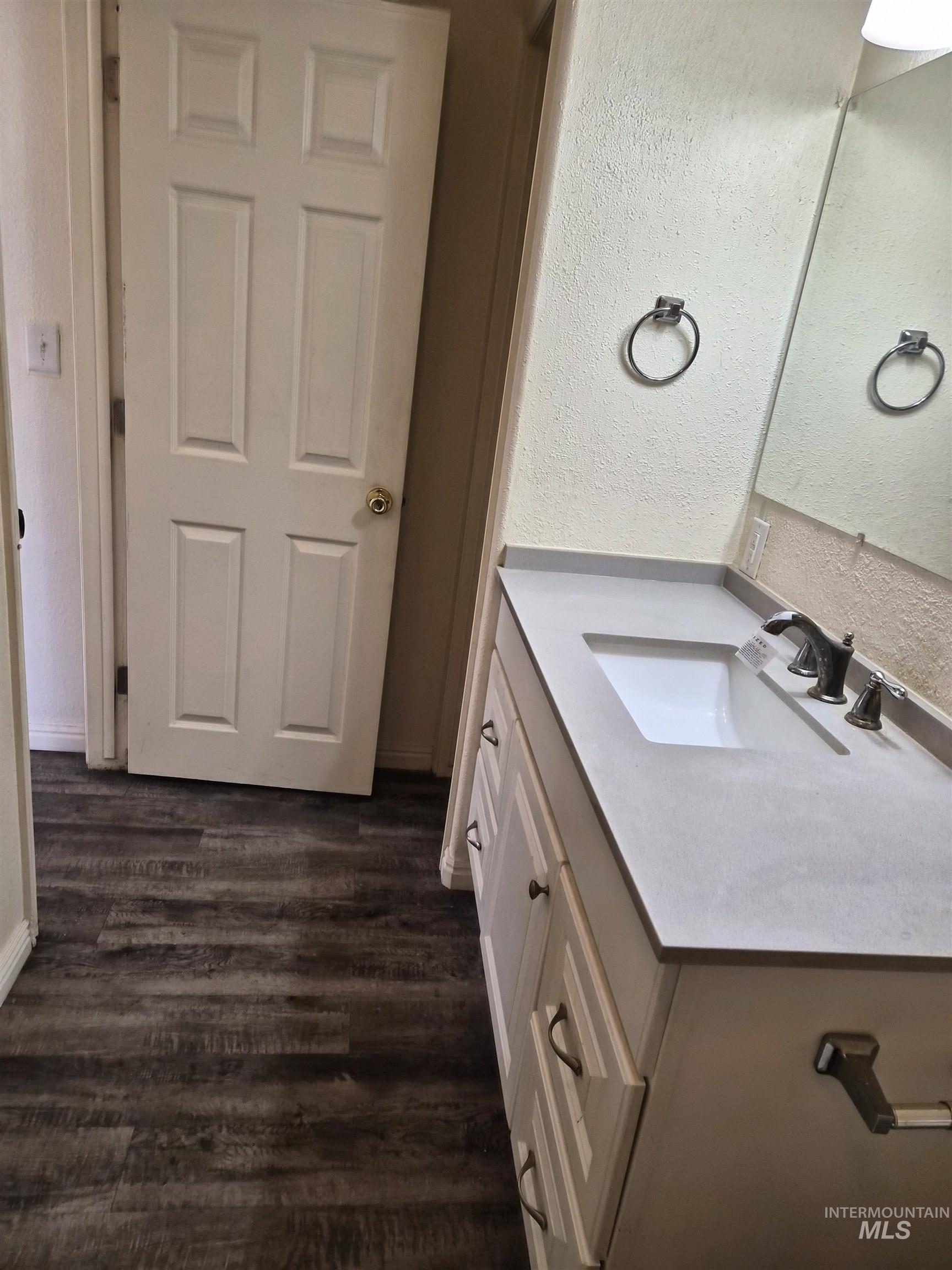 682 Randolph Avenue Pocatello, ID 83201 - Photo 7 of 29 Bathroom featuring vanity, a textured wall, and dark wood-type flooring