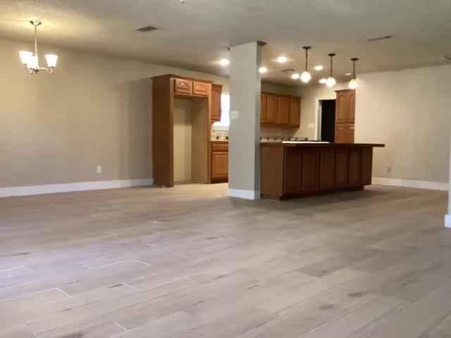 an empty room with a fireplace cabinet and window