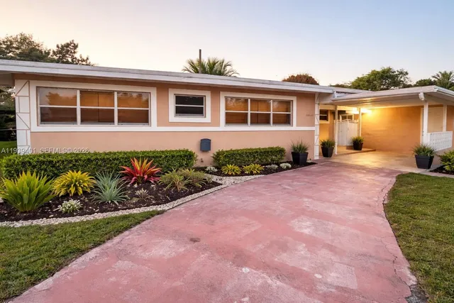a front view of a house with a garden and yard
