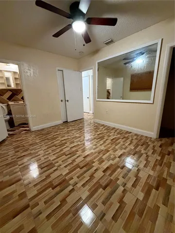 a view of empty room with wooden floor