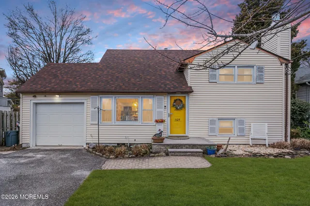 a front view of a house with a yard and outdoor seating
