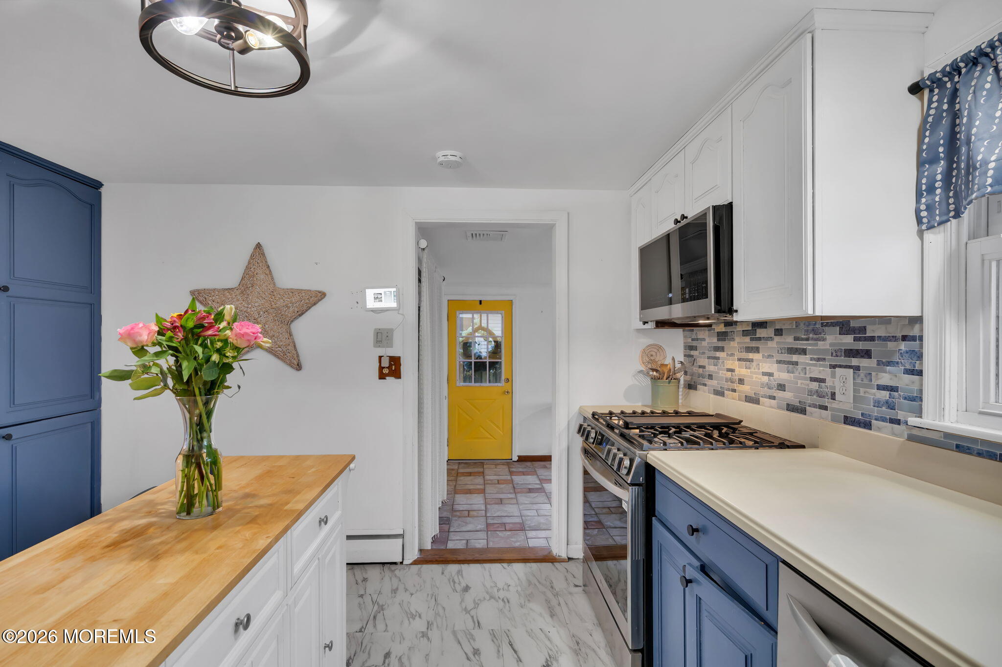 1129 Roe Avenue Point Pleasant, NJ 08742 - Photo 17 of 71 a kitchen with stainless steel appliances granite countertop a sink a stove a microwave a dining table and chair with wooden floor