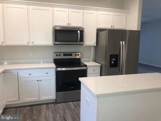 a kitchen with a refrigerator sink and cabinets