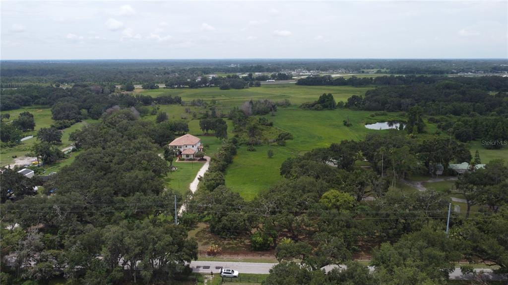 6501 Muck Pond Road Seffner, FL 33584 - Photo 3 of 21 a aerial view of green landscape with trees houses and mountain view