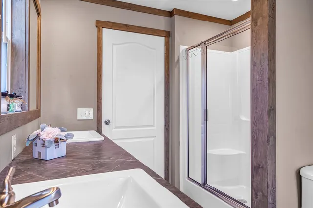 a bathroom with a granite countertop sink mirror vanity and toilet