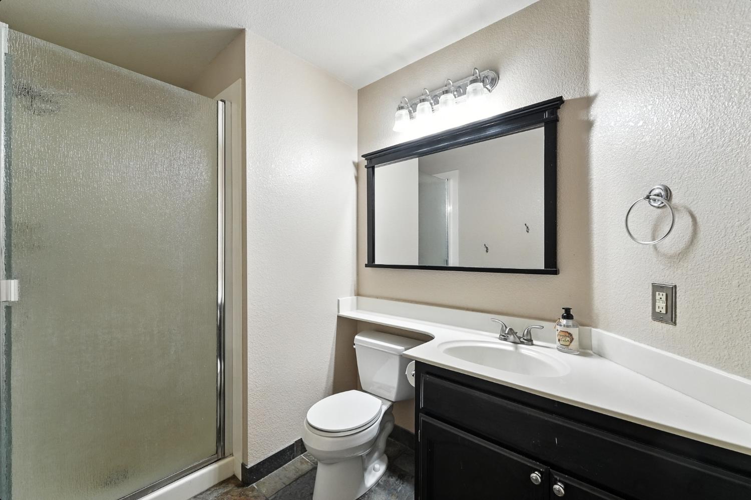 834 Cedar Ridge Drive Turlock, CA 95382 - Photo 31 of 57 a bathroom with a toilet sink vanity and mirror