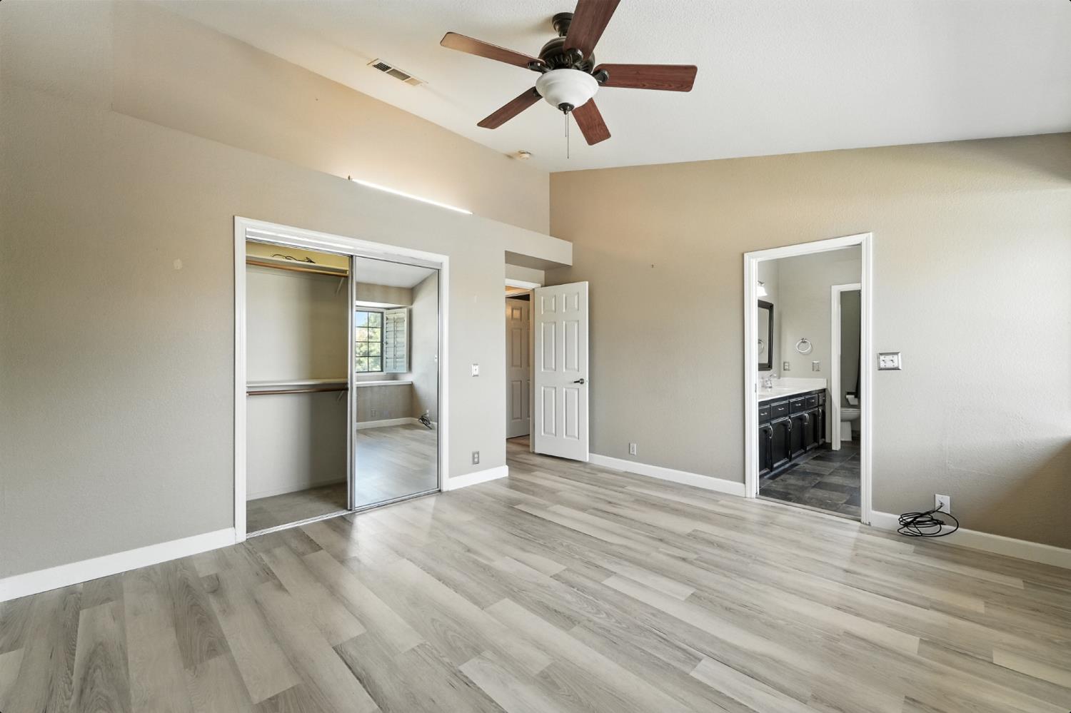 834 Cedar Ridge Drive Turlock, CA 95382 - Photo 42 of 57 a view of an empty room with wooden floor and a ceiling fan