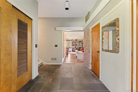 a living room with furniture a bookshelf and a window