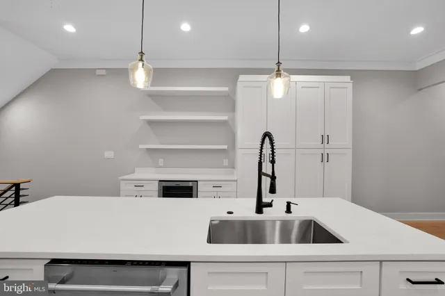 a kitchen with kitchen island a sink appliances and a counter top space