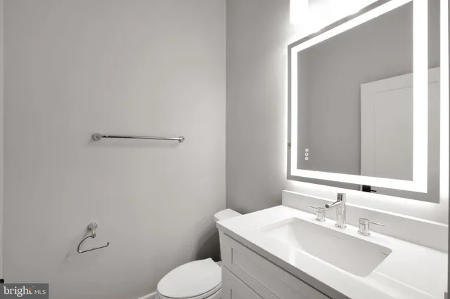a bathroom with a sink mirror vanity and toilet