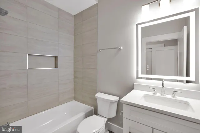 a bathroom with a sink toilet vanity and tub