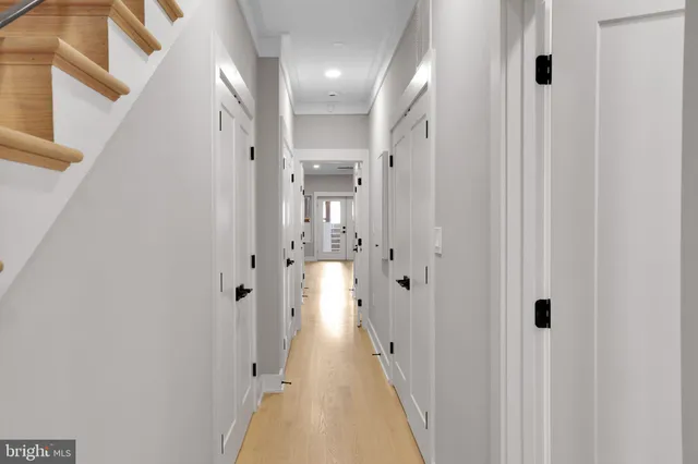 a view of a hallway with a cabinet and a chandelier
