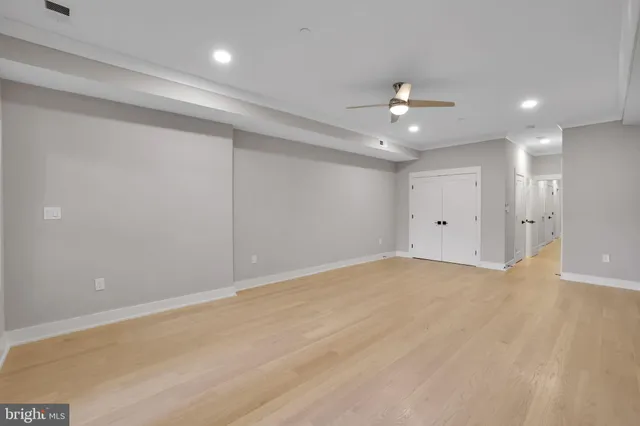 wooden floor in an empty room with a ceiling fan