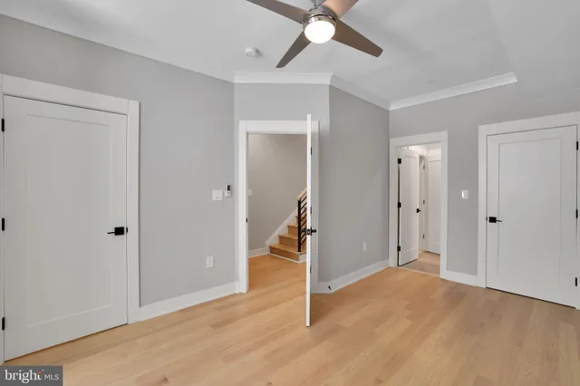 a view of a livingroom with wooden floor and a ceiling fan