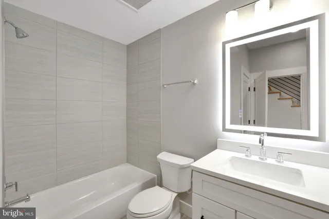 a bathroom with a sink toilet vanity and tub