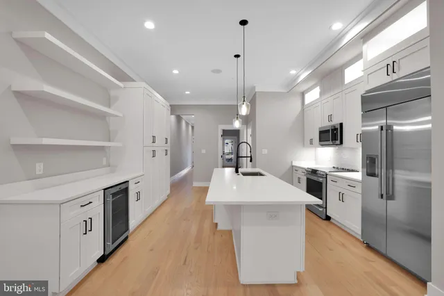 a large kitchen with stainless steel appliances kitchen island granite countertop a large kitchen island a stove and a refrigerator