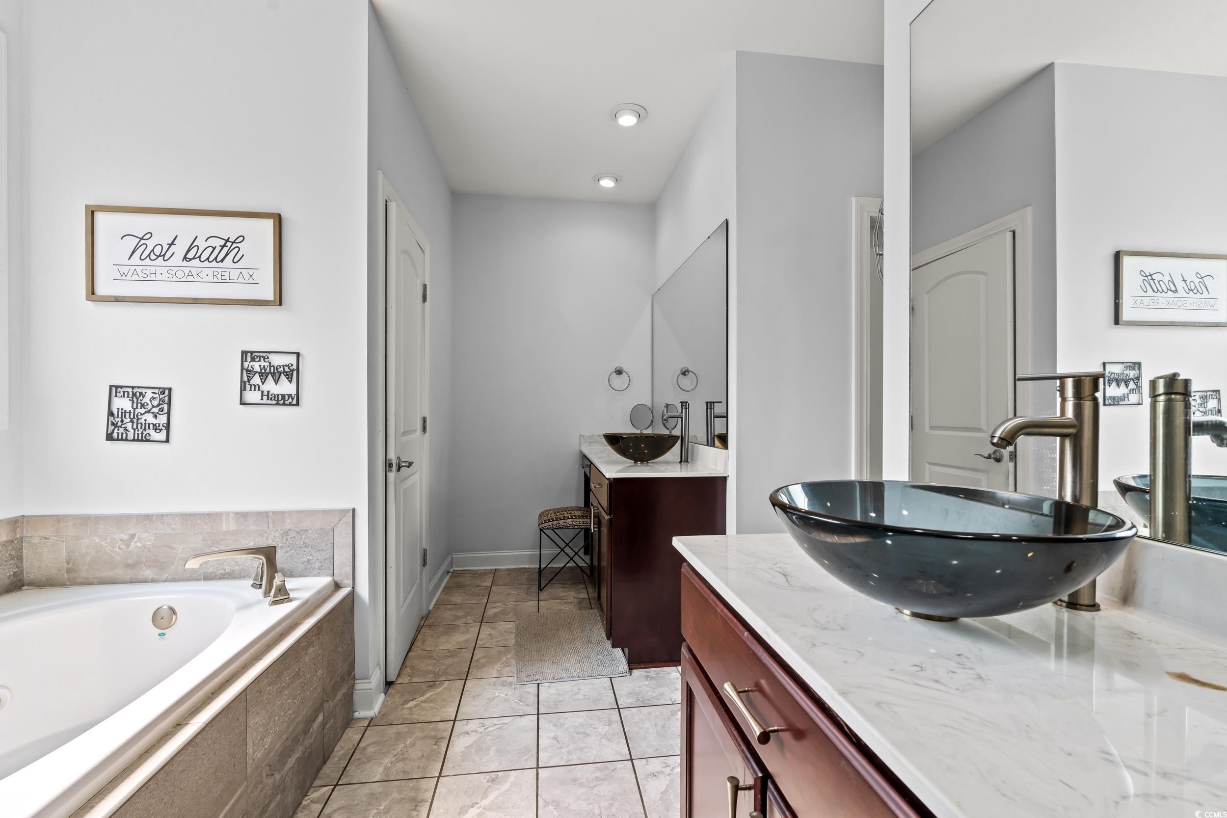 1051 Academy Drive Conway, SC 29526 - Photo 14 of 37 Full bathroom with two vanities, a garden tub, recessed lighting, and baseboards
