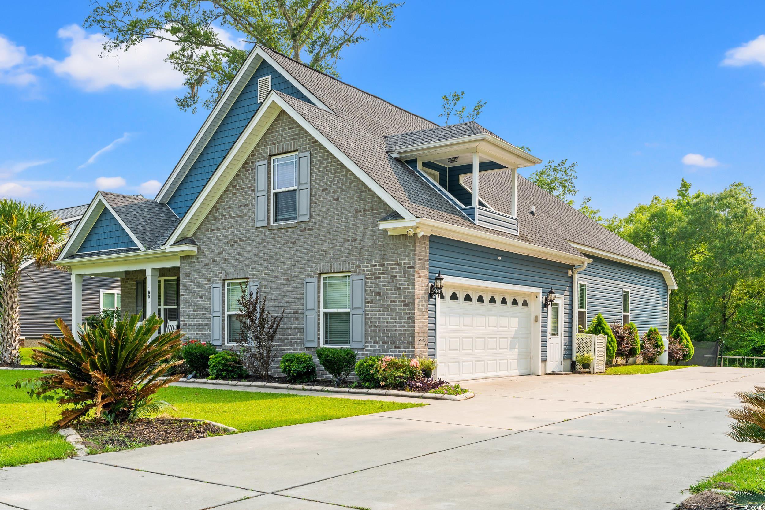 1051 Academy Drive Conway, SC 29526 - Photo 2 of 37 View of front facade featuring driveway, a garage, a front lawn, and a shingled roof