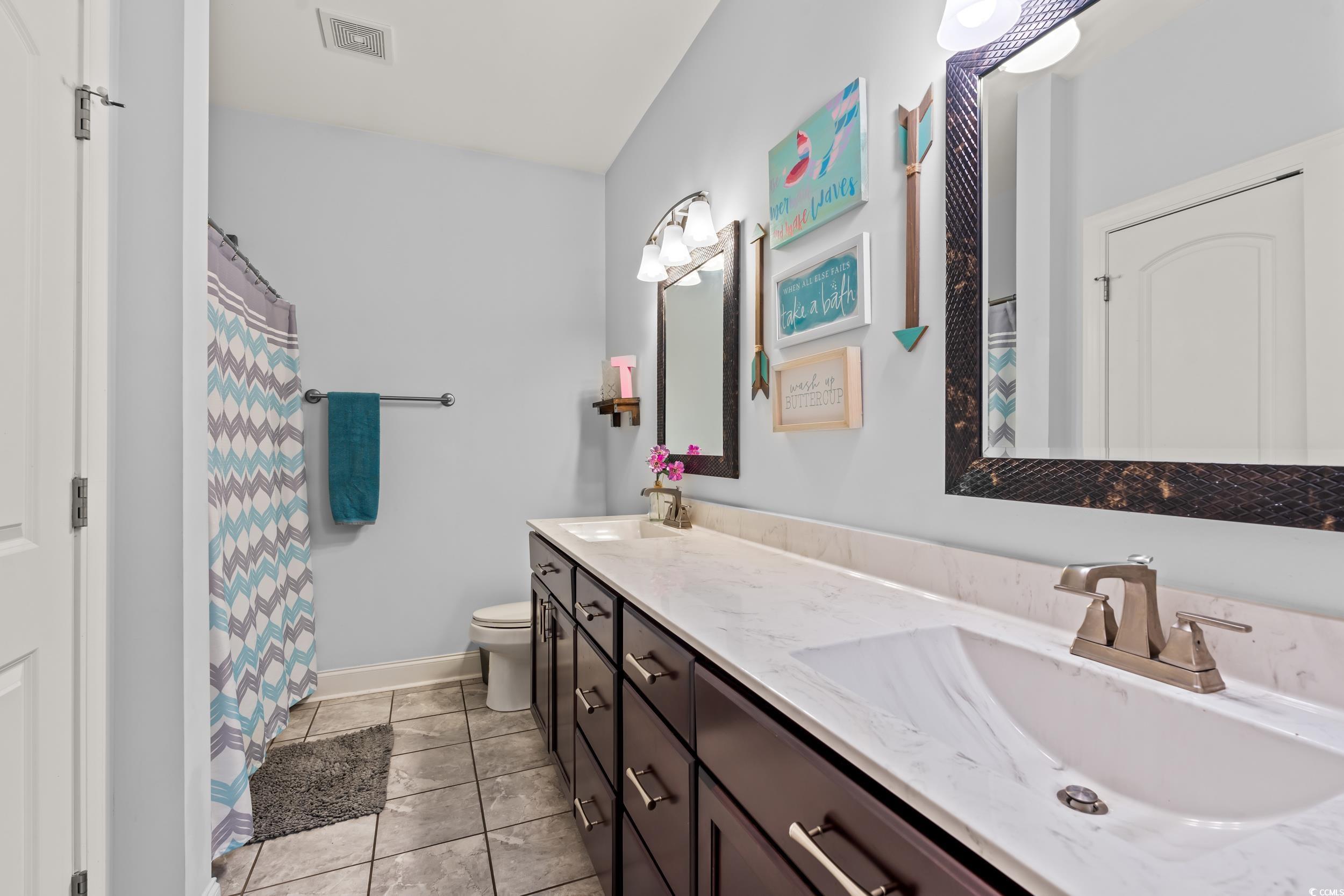 1051 Academy Drive Conway, SC 29526 - Photo 21 of 37 Bathroom featuring double vanity, toilet, baseboards, and a shower with shower curtain