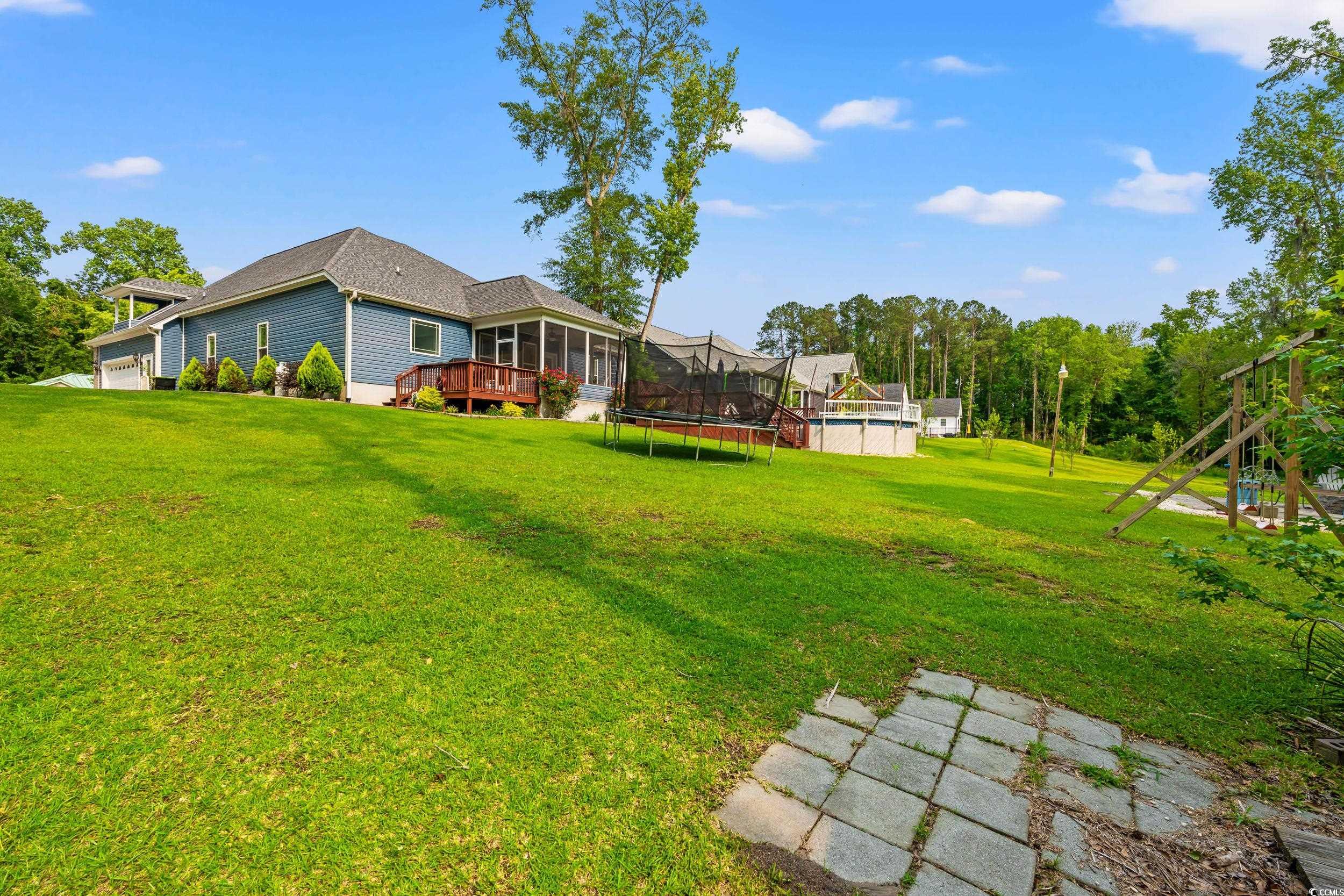 1051 Academy Drive Conway, SC 29526 - Photo 27 of 37 View of green lawn featuring a wooden deck and a trampoline