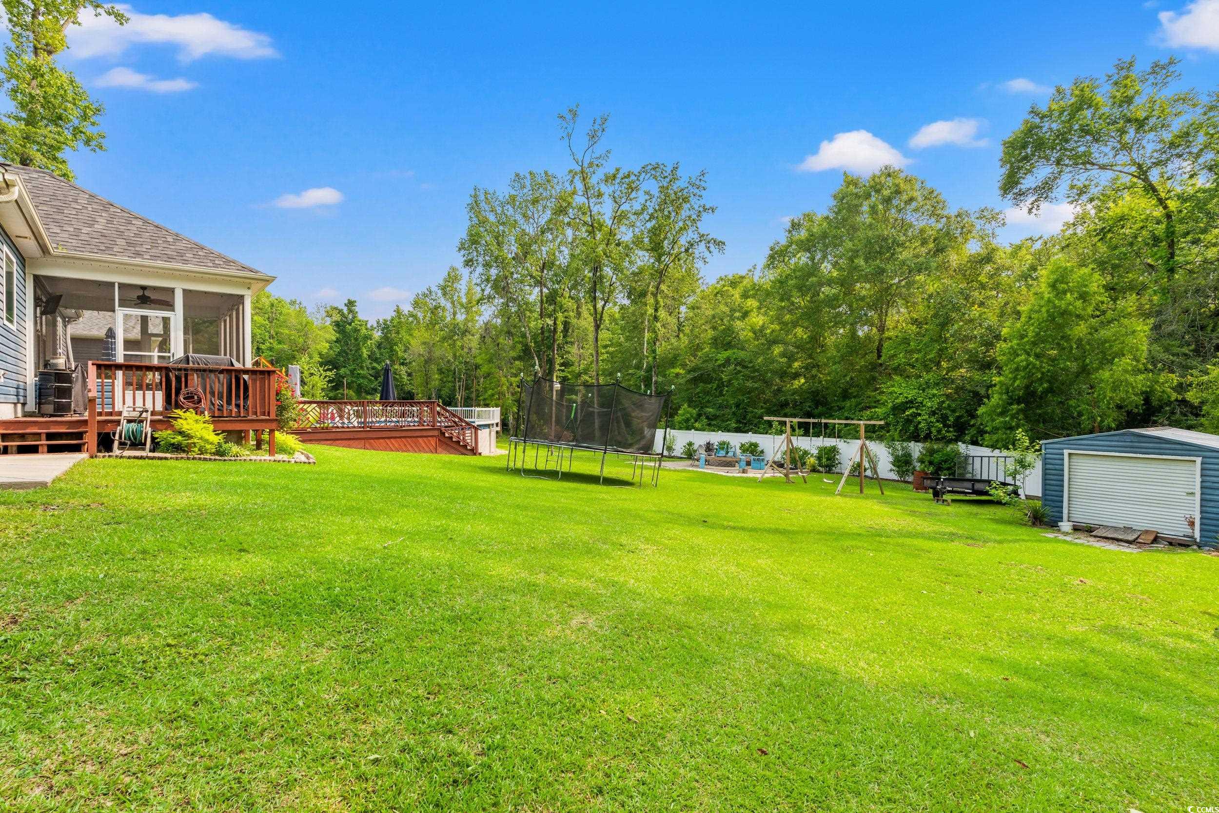 1051 Academy Drive Conway, SC 29526 - Photo 28 of 37 View of yard featuring a trampoline, a deck, a sunroom, and a playground