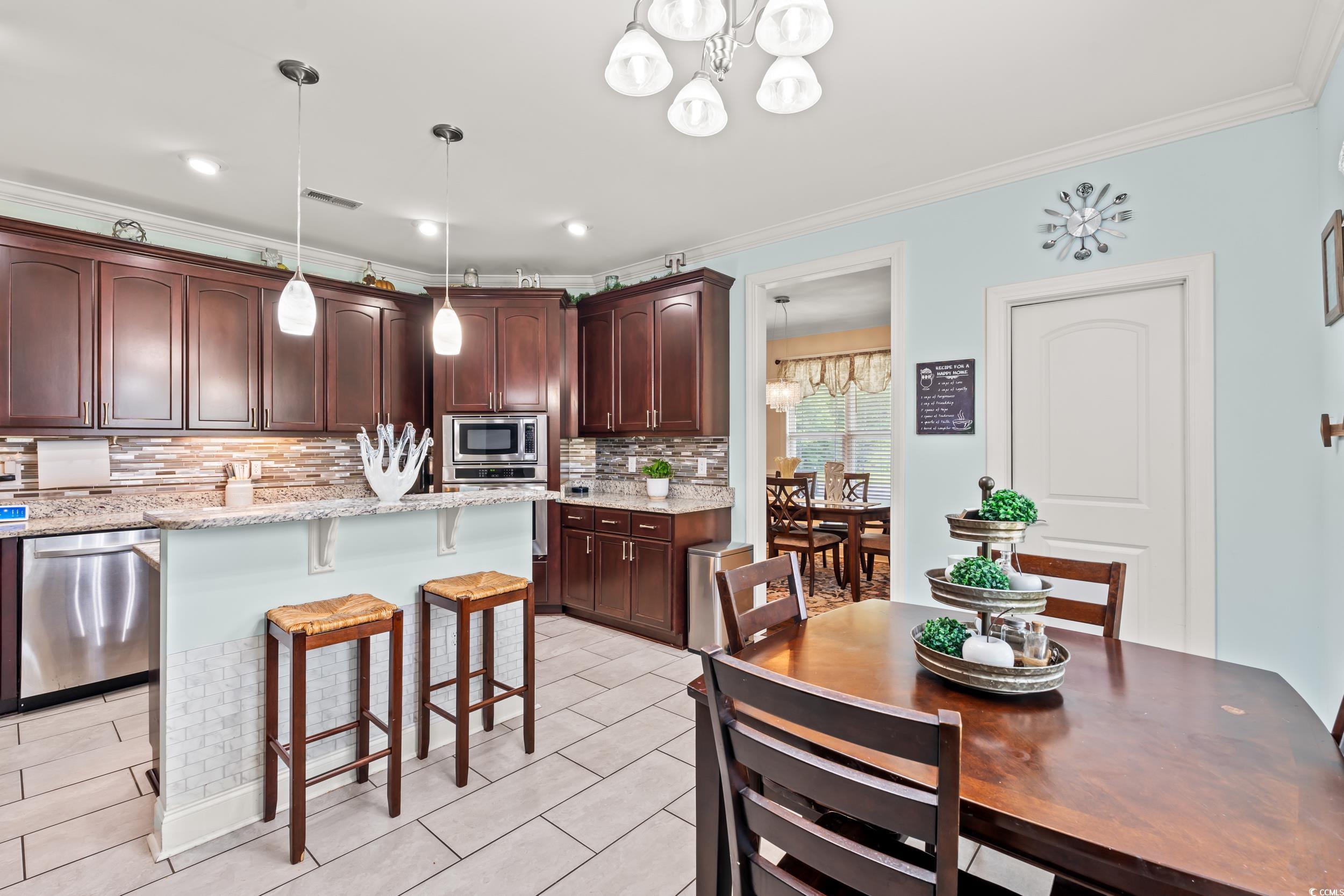1051 Academy Drive Conway, SC 29526 - Photo 9 of 37 Kitchen with stainless steel appliances, ornamental molding, a kitchen breakfast bar, a chandelier, and decorative backsplash