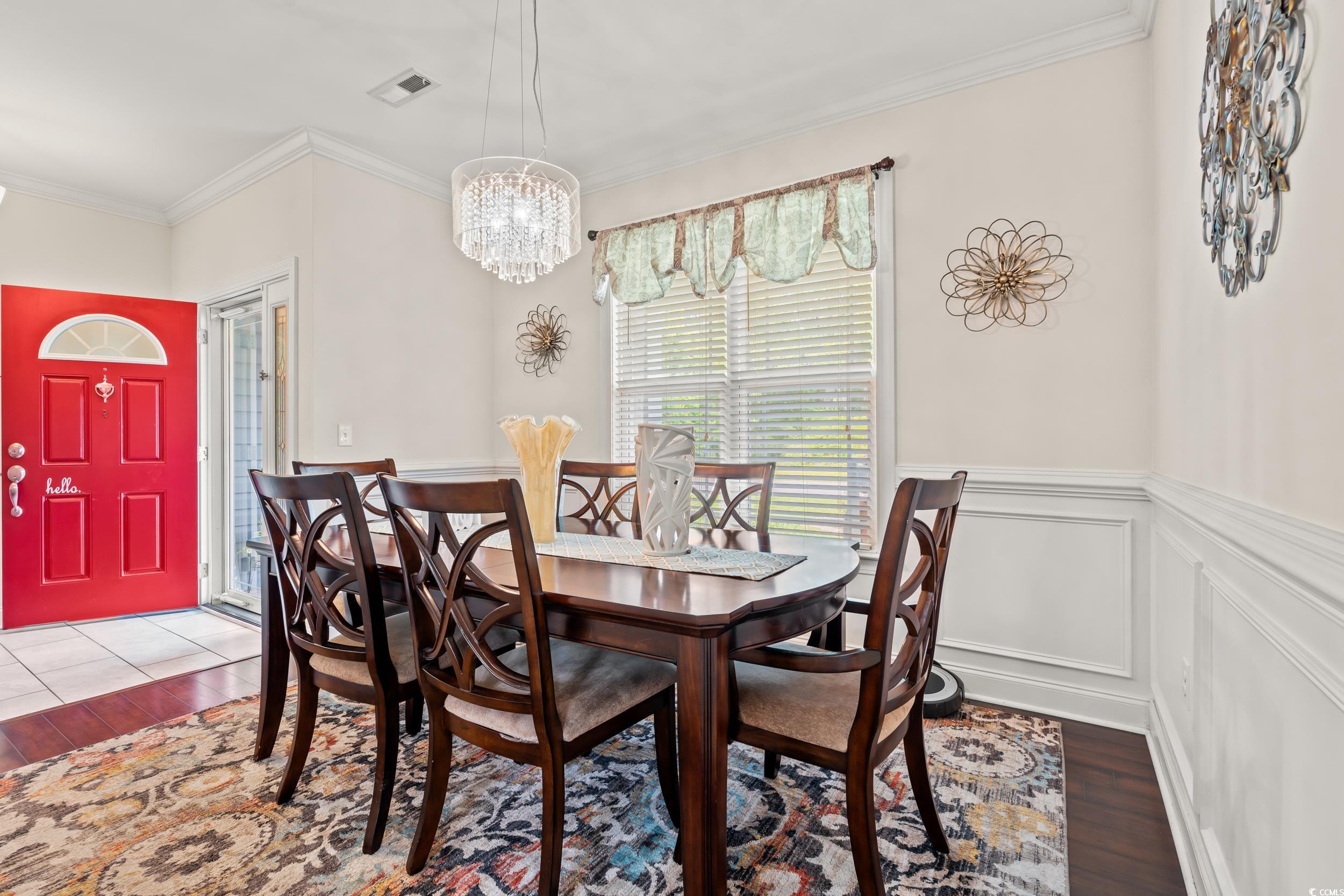 1051 Academy Drive Conway, SC 29526 - Photo 10 of 37 Dining area with wood finished floors, crown molding, a chandelier, and a wainscoted wall