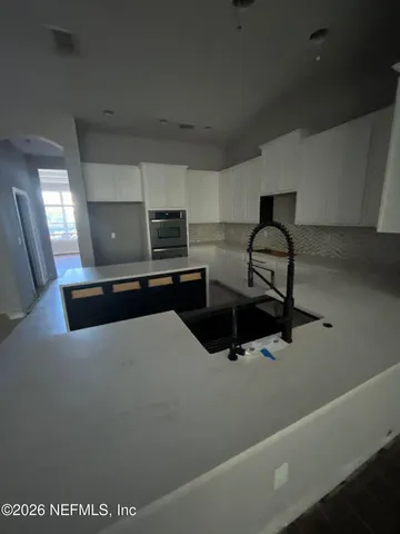 a kitchen with a sink a stove and cabinets