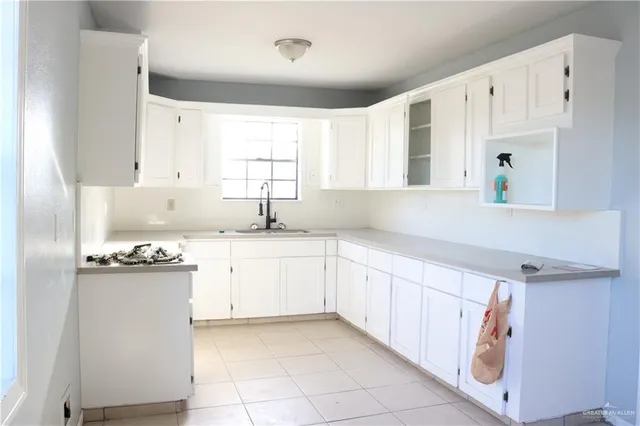 a kitchen with a sink window and cabinets