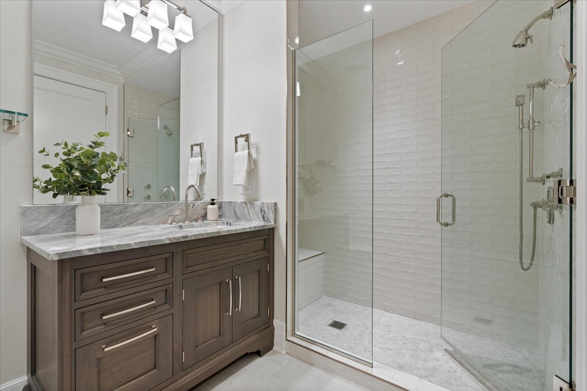 9 West Walton Street, Unit 702 Chicago, IL 60610 - Photo 32 of 38 a bathroom with a shower sink and mirror