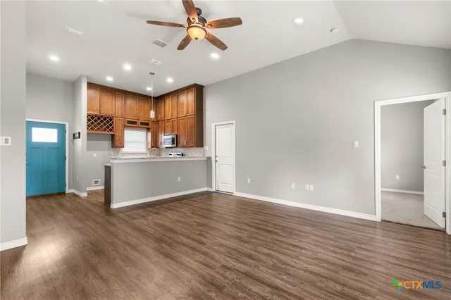 a kitchen with stainless steel appliances kitchen island a refrigerator sink and cabinets