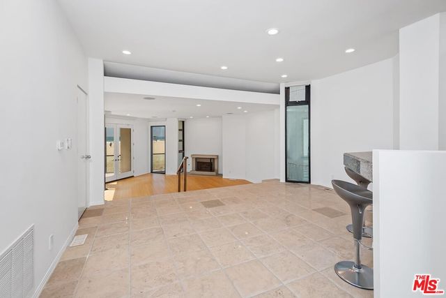 a view of an empty room with glass door and a window