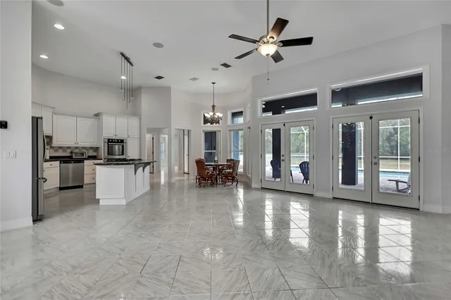 a view of an empty room with a chandelier fan