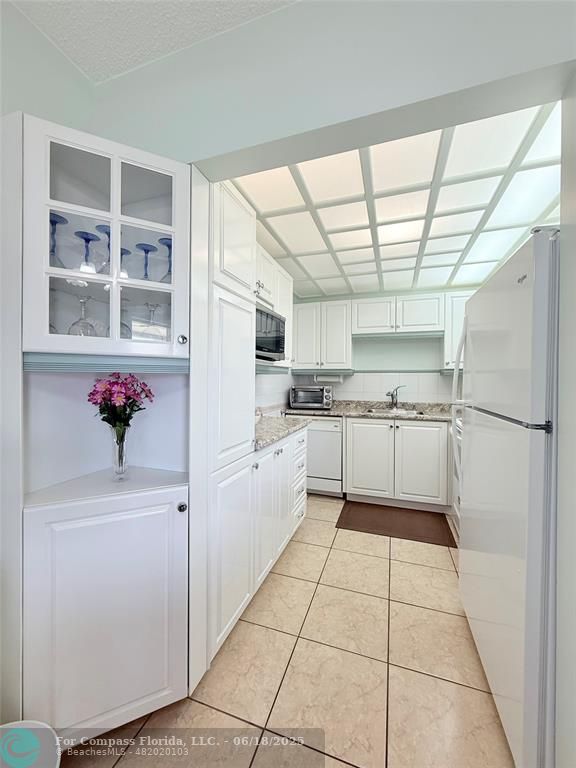 15 Markham A, Unit 15 Deerfield Beach, FL 33442 - Photo 12 of 45 a kitchen with white cabinets and white appliances