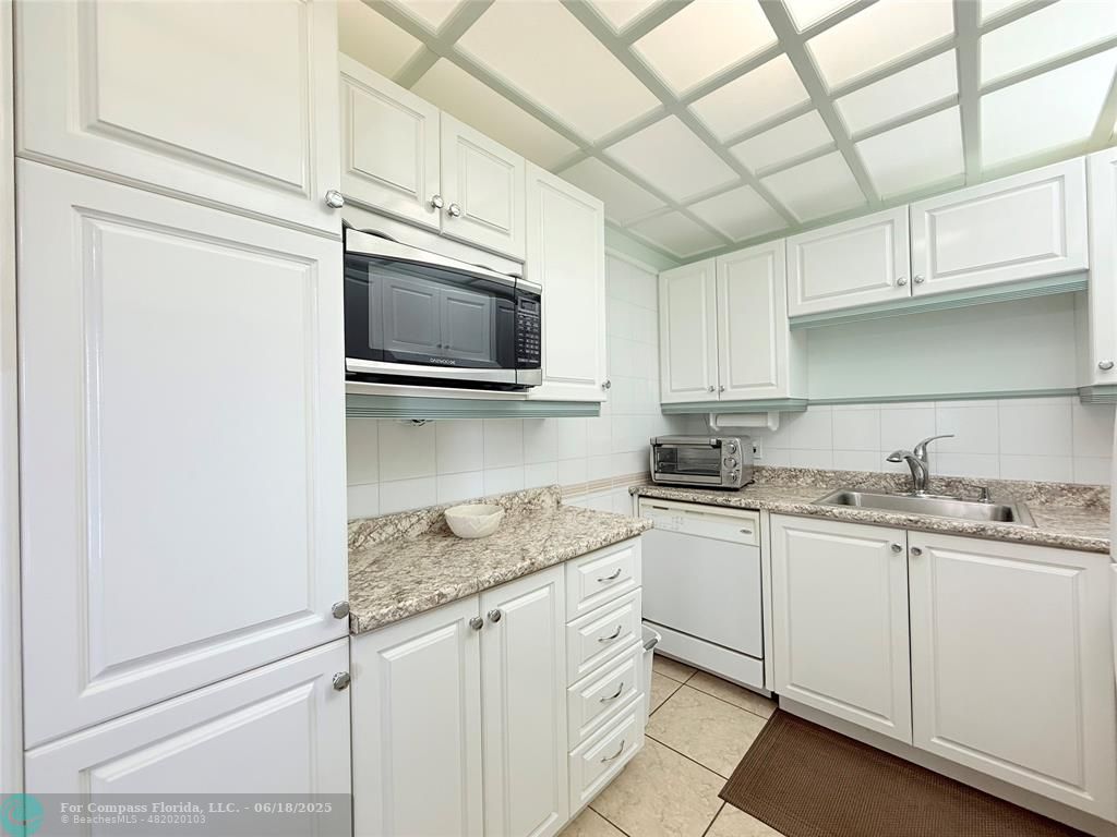 15 Markham A, Unit 15 Deerfield Beach, FL 33442 - Photo 13 of 45 a kitchen with stainless steel appliances granite countertop a sink a stove and microwave