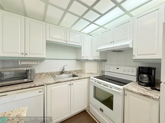 a kitchen with stainless steel appliances granite countertop a sink and a stove