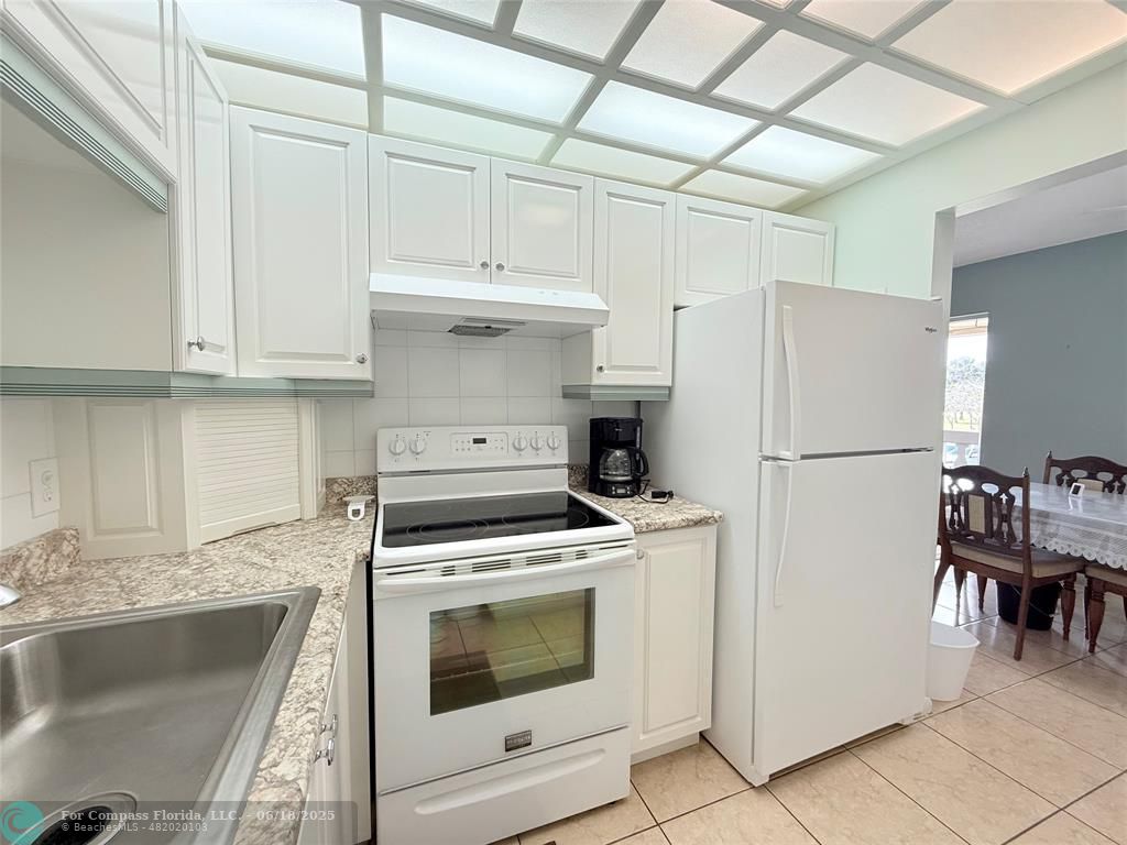 15 Markham A, Unit 15 Deerfield Beach, FL 33442 - Photo 16 of 45 a kitchen with a stove top oven and refrigerator