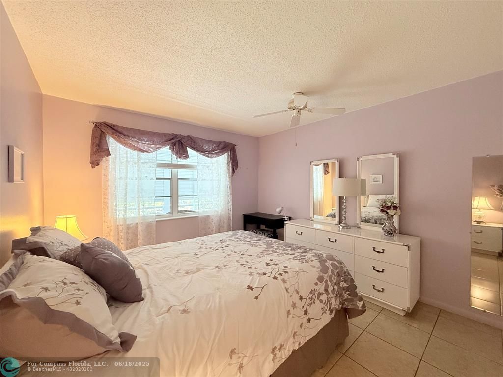 15 Markham A, Unit 15 Deerfield Beach, FL 33442 - Photo 24 of 45 a large bedroom with a bed and a dresser