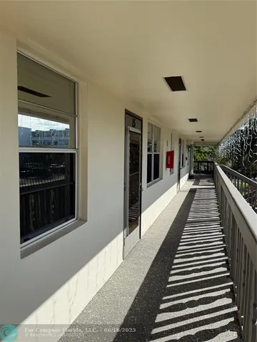 a hallway with wooden floor windows and entryway