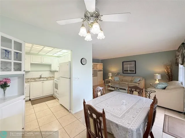 a kitchen with stainless steel appliances kitchen island granite countertop a sink refrigerator and cabinets