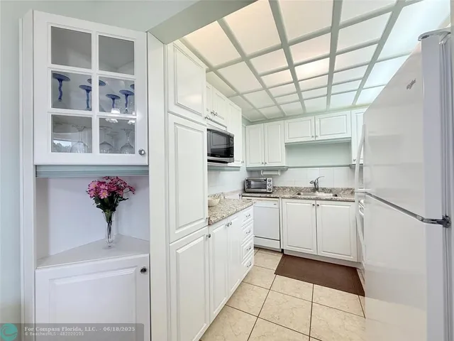 a kitchen with stainless steel appliances white cabinets and a window